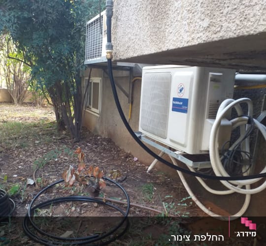 צינורות ומזגן מותקן על קיר חיצוני